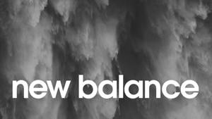 在煙霧灰色抽象背景上的白色文字New Balance標誌。