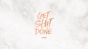 勵志語句 get shit done 以銅色畫筆寫在紋理背景上
