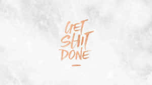 在紋理白色背景上以銅色筆觸書寫的勵志短語 get shit done。 — 極簡美學桌面 壁紙