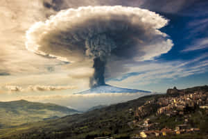 火山爆發，火山灰雲籠罩山峰和城鎮 — 山景 壁紙