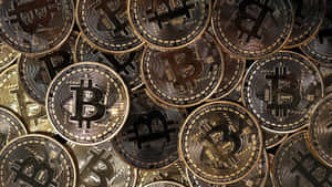 一堆帶有雕刻符號的金色比特幣加密貨幣硬幣。 — 比特幣 GIF 壁紙