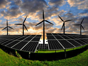 日落時分草地上的太陽能板和風力發電機。 — 閃電麥坤 壁紙