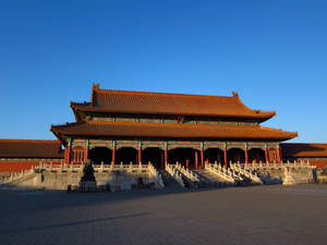 令人印象深刻的中國古代宮殿，橙色屋頂和紅色柱子沐浴在金色的夕陽中。 — 中國 壁紙