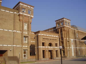 國家美術館建築，磚砌外牆和拱形門口，在藍天下。 — 巴基斯坦 壁紙