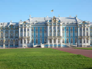 宏偉的藍白巴洛克式宮殿，帶有金色飾邊，在晴朗的天空下與修剪整齊的草坪。 — 俄羅斯 壁紙