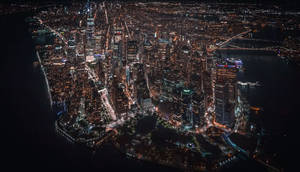 明亮城市夜景航拍圖，高樓大廈和河畔橋樑。 — 城市風景 壁紙