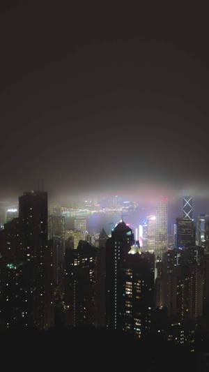 夜晚的城市天際線，燈火通明的建築物和迷濛的氛圍。 — 城市燈光 壁紙