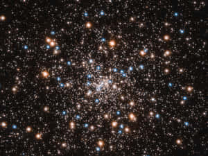 在黑色天空中閃耀著橙色和藍色星星的密集星團。 — 星星 壁紙