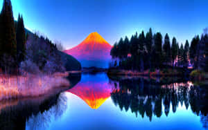 富士山在暮色中發出橙色光芒，倒映在平靜的湖泊中。 — 魔法森林 壁紙