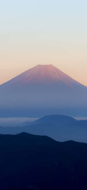 日出時的富士山，下方有霧氣層層的山脈 — 簡約 iPhone 壁紙