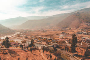 秋天的山村，河流與蜿蜒道路在藍天下。 — 不丹 壁紙