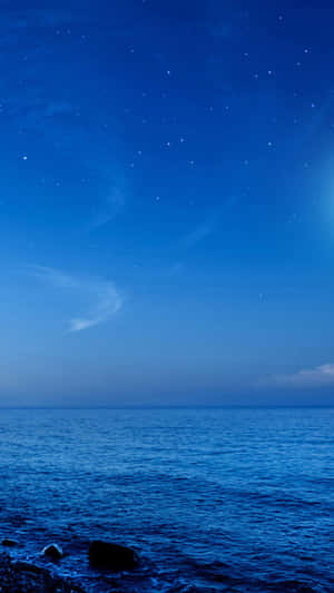 岩石海岸上平靜海洋的星空之夜 — 三星Galaxy 壁紙