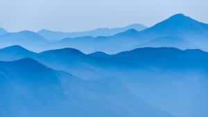 藍色山脈在晴朗天空下逐漸消失於大氣薄霧中。 — 山脈 壁紙