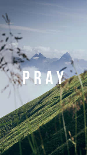 綠色山坡，遠處有山峰，並疊加了PRAY這個詞。 — 蠟燭 壁紙