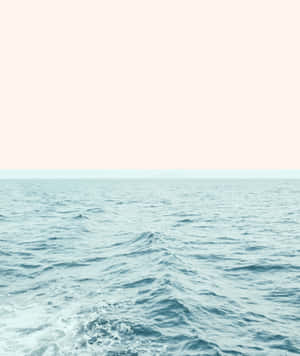 在柔和粉彩天空下，平靜的海洋波浪與遙遠的地平線。 — Pixel Fold 壁紙
