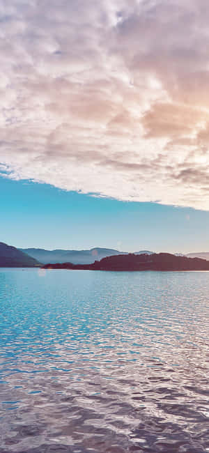 日出時分的寧靜湖泊，有山脈和粉彩天空 — 自然 iPhone 壁紙