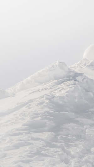 薄霧中的雪山頂，柔和光線 — 白色 iPhone 壁紙