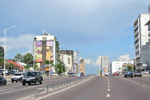 繁忙的城市街道，車輛和高樓大廈，在清澈的藍天下。 — 鄉村道路 壁紙