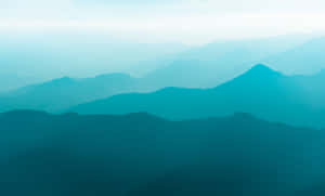 寧靜的山景，層疊的山峰在藍色薄霧中逐漸消失。 — 青色GIF 壁紙