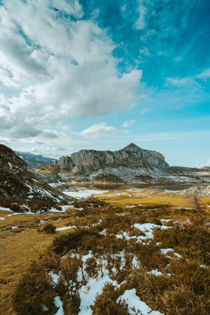 白雪覆蓋的山景，金色的草地，藍天白雲 — 岩石 壁紙