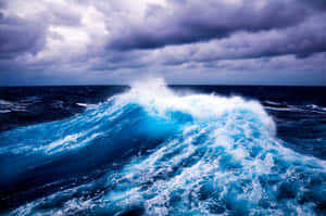 高聳的海浪在暴風雨的天空下翻騰，激起白色泡沫。 — 海灘日落 壁紙