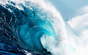 強勁的藍綠色海浪捲成桶狀，帶有白色泡沫。