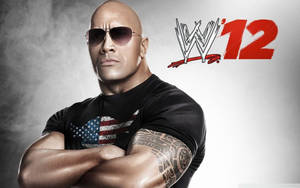 巨石強森在WWE 12宣傳照中雙臂交叉並戴太陽眼鏡。 — 摔角 壁紙