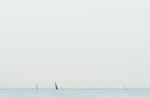 朦朧天空下平靜海面上的帆船 — 帆船 壁紙