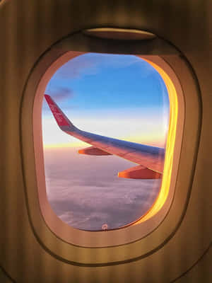 透過窗戶看到亞洲航空飛機機翼在日落時分雲層上方。 — 天空景色 壁紙