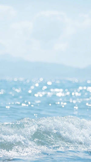 晴朗藍天下，陽光閃爍的溫柔海浪。 — 海景 壁紙