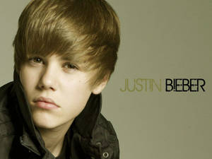 年輕的Justin Bieber穿著深色外套的工作室肖像，旁邊有他的名字文字。 — 小賈斯汀 壁紙