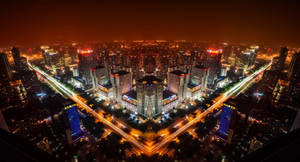 充滿活力的城市夜間航拍，建築物燈火通明，車輛移動形成光跡。 — 唐人街 壁紙