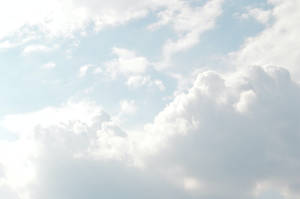 柔和的藍色天空，有蓬鬆的白雲和陽光穿透。 — 雲朵 GIF 壁紙
