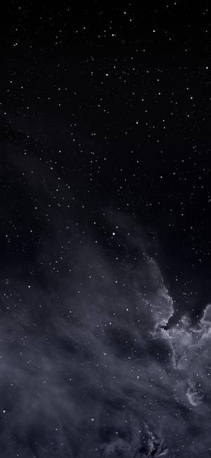 繁星點點的夜空，有發光的星雲和宇宙塵埃雲。 — 深色模式 壁紙