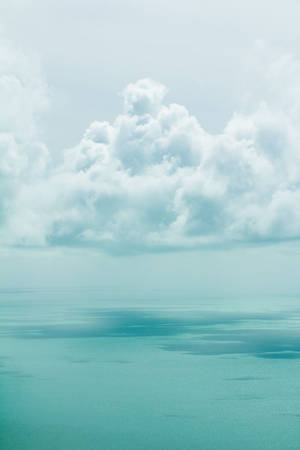 柔軟的白雲下，寧靜的藍綠色海洋，地平線平靜。 — 美學雲朵 壁紙