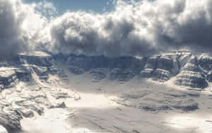 戲劇性多雲天空下的雪山山谷 — 冬季風景 壁紙