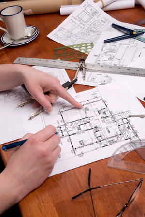 建築師的手在木桌上繪製和指向建築藍圖，並有繪圖工具。 — 工作 壁紙