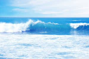 巨大的海浪在清澈的藍天下帶著白色泡沫破碎。 — 海洋桌面 壁紙