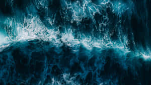 航拍視圖中撞擊的海浪，帶有深藍色海水和白色泡沫。 — 海洋 壁紙