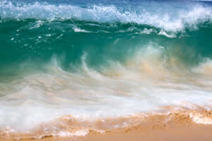 碧綠色海浪拍打金色沙灘，帶有白色泡沫。 — 海灘日落 壁紙