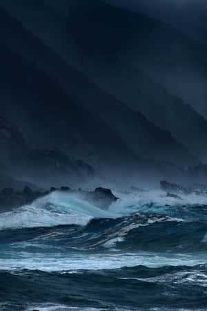暴風雨的海浪在陰暗的天空下衝擊著岩石懸崖。 — 海洋 壁紙