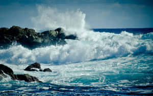 海浪拍打著海洋中的黑暗岩石，產生白色浪花。 — 波浪 壁紙