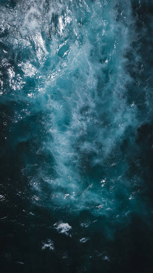 從上方看到的，在深藍色海水中撞擊的帶有白色泡沫的洶湧海浪。 — 海軍藍 壁紙
