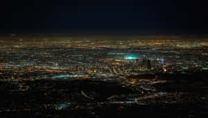 夜間從空中俯瞰廣闊城市，燈光閃爍。 — 天使 GIF 壁紙