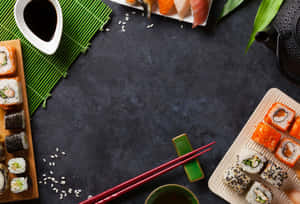 深色石板上的各種壽司卷和刺身，附有筷子和醬油。 — 壽司 壁紙