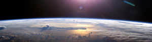 日出時從太空看地球，雲層和海洋在金色光芒中閃耀。 — 宇宙 壁紙