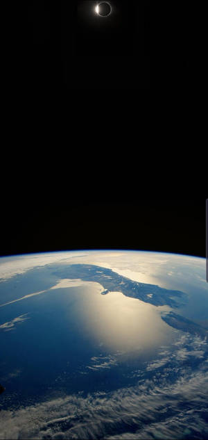 從太空觀看地球在日食期間，月球部分遮蓋太陽。 — 太空 4K 手機 壁紙