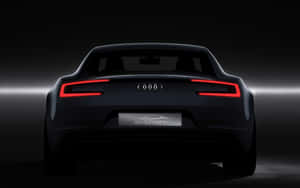 在黑暗的攝影棚中，時尚黑色Audi e-tron電動車帶有發光的紅色尾燈。 — 奧迪 GIF 壁紙