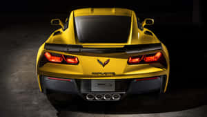 黃色Corvette跑車後視圖，尾燈在黑暗的攝影棚中亮起。