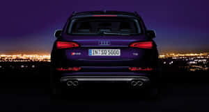 夜間紫色奧迪 SQ5 SUV，俯瞰燈光璀璨的城市。 — 奧迪 GIF 壁紙